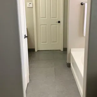 a bathroom with a door and a bathtub