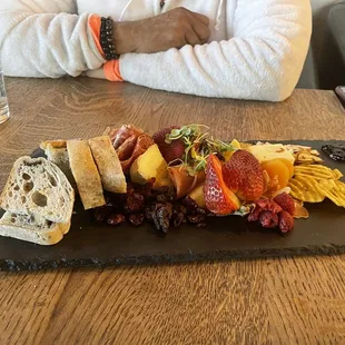 Charcuterie tray with smoked and spicy cheeses, meats and fresh fruits and nuts