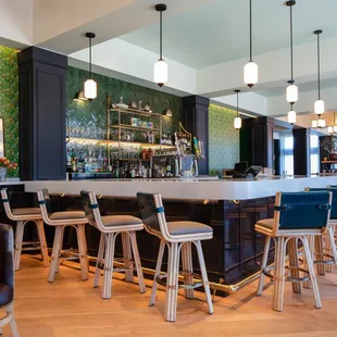 a bar with stools and tables
