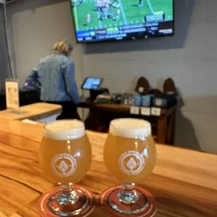 two glasses of beer on a bar