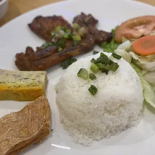 a plate of rice, meat, and vegetables