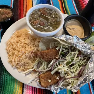 The tilapia fried fish tacos with chipotle cream sauce cabbage and pico de gallo served with Spanish rice and a side of lentejas.