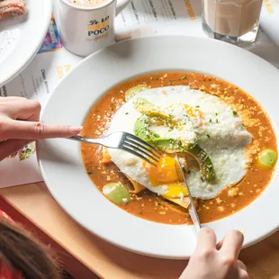 The best Huevos rancheros in town! Corn Tortillas, refried black beans, salsa ranchera, avocado, avocado mousse, 2 sunny eggs