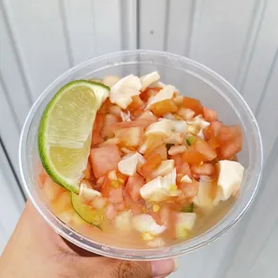 a hand holding a bowl of food