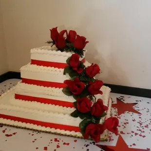 a wedding cake with red roses