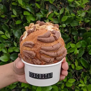a person holding a cup of ice cream