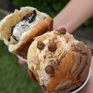 a person holding two ice cream sandwiches