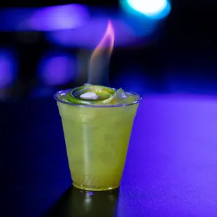 a shot of a drink with a flame coming out of it