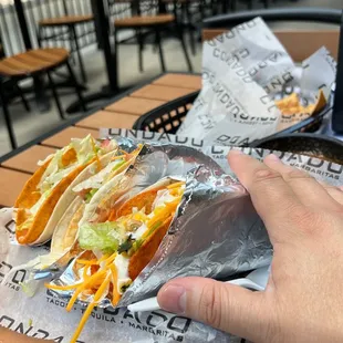 a hand holding a taco