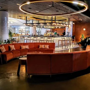 a circular seating area with a bar in the background