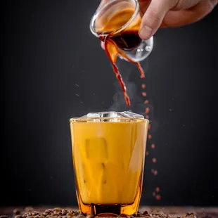 a person pouring coffee into a cup