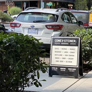 a sign on the sidewalk in front of a building