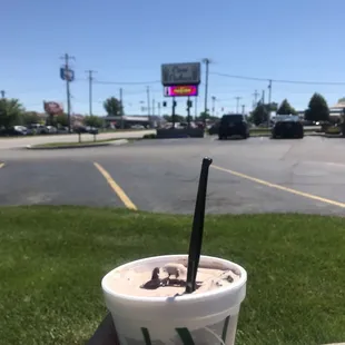 a hand holding a cup of ice cream