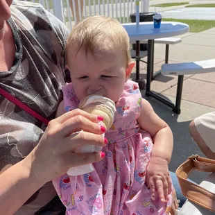 a woman feeding a baby with a bottle