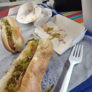 two hot dogs with pickles and mustard