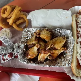 a hot dog with wings and onion rings