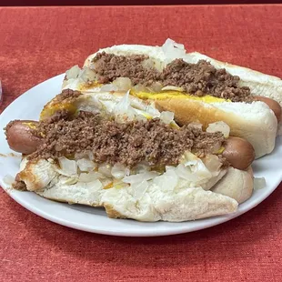 two hot dogs with mustard and onions