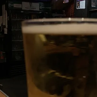 a glass of beer in front of a television
