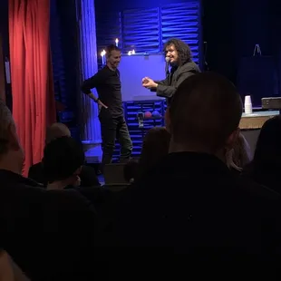 Magician Ritchy Flo onstage with audience member.
