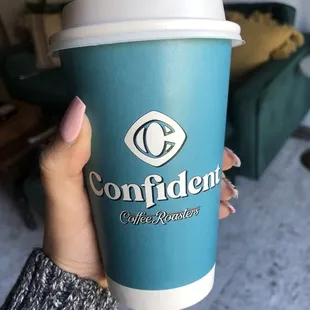 a hand holding a cup of coffee