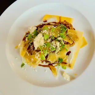 Aged Gouda &amp; Caramelized Onion Tart, Iberico Chorizo, horseradish, sunflower seed, arugula, pom. molasses, freeze dried honey