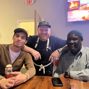 three men sitting at a table