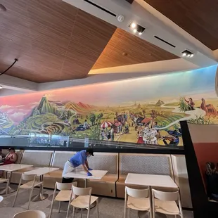 a man cleaning tables in a restaurant