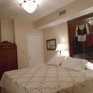 Framed authentic Slovak dress is above the King bed.  Framed passports and marriage license is the the left of lamp.