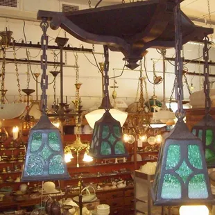 Arts and craft style ceiling fixture in original finish with three stained glass shades.