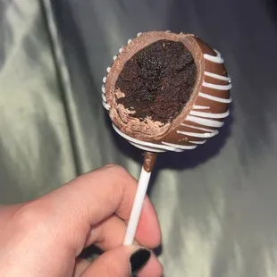 a hand holding a chocolate cake pops