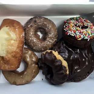 CW from top-left: buttermilk bar w/ cream, blueberry cake, choc. cake w/ sprinkles, apple fritter, cruller, old fashioned w/ maple