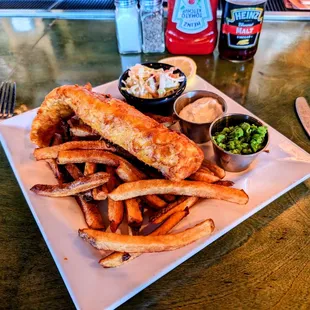 Fish and chips, tartar sauce, mushy peas, coleslaw, malt vinegar.