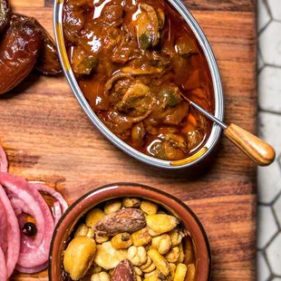 a wooden cutting board with meat and vegetables