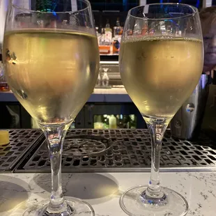 two glasses of wine on a bar
