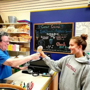 a woman handing a donut to a man