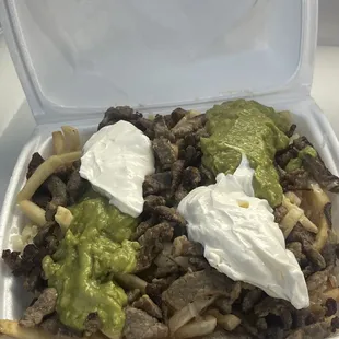 Carne asada fries with two glob of avocado and two glob of sour cream....yyuupp you&apos;re looking at it right
