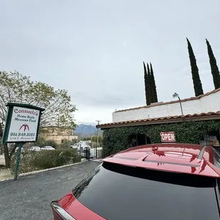 a red car parked in front of a restaurant