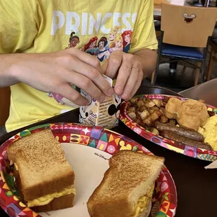 Egg sandwich, waffles, scrambled eggs, sausage, and potatoes.