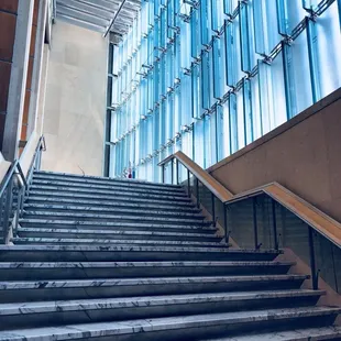 Marble &quot;floating&quot; staircase leading up to second floor mezzanine.  Note glass &quot;fins&quot; in windows that follow the sunlight