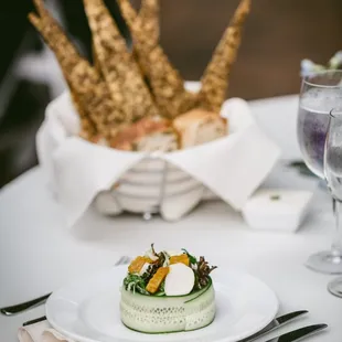 Plated salad course and bread basket