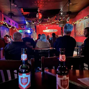 people sitting at a table with two bottles of beer