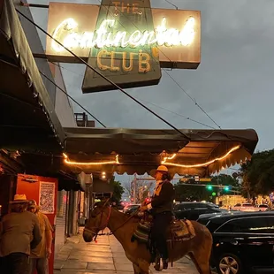 a man riding a horse on the sidewalk