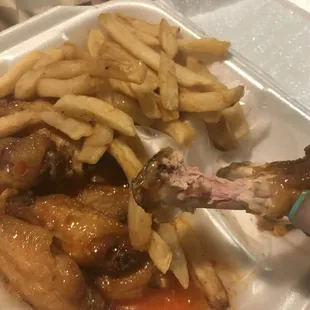 a plate of chicken wings and french fries