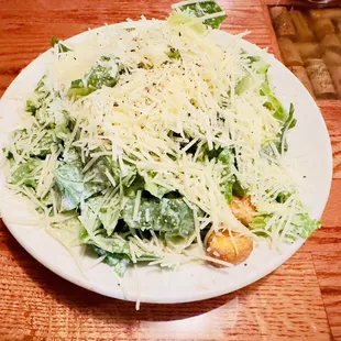 a plate of salad on a wooden table