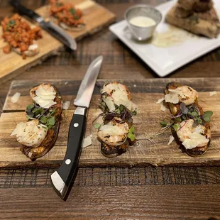 a cutting board with a knife and a variety of appetizers