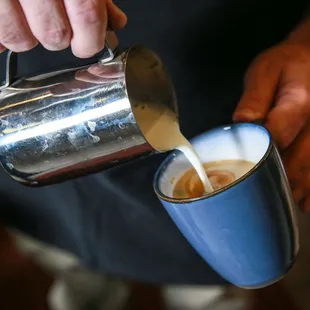 a person pouring a cup of coffee