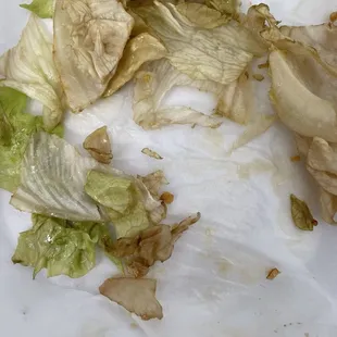 Rotten lettuce under chicken wings. No, that's not soy sauce.  Ordered chicken wings with no seasoning.