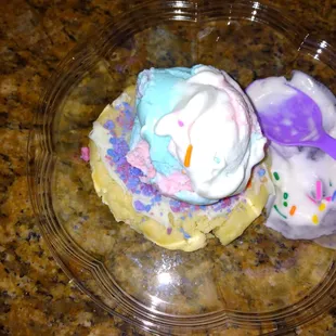 two cupcakes with sprinkles and a spoon