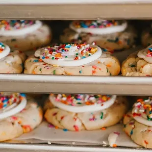 a tray of cookies with frosting and sprinkles