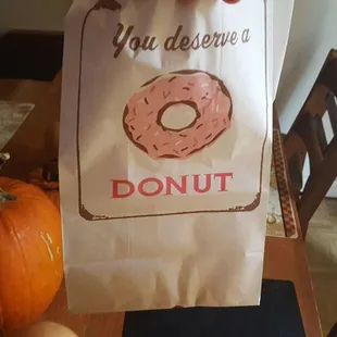 a person holding a bag of donuts